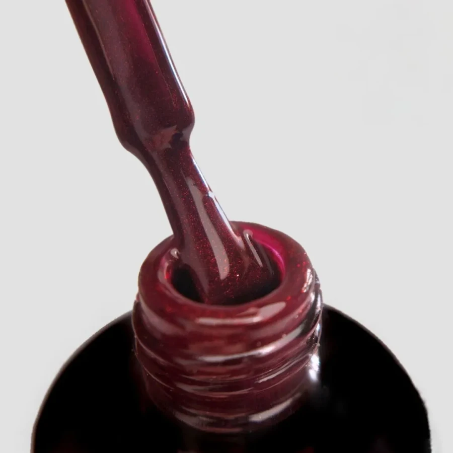 Ciemny burgund z delikatną drobinką to nieoczywista wariacja na temat klasycznego czerwonego manicure.