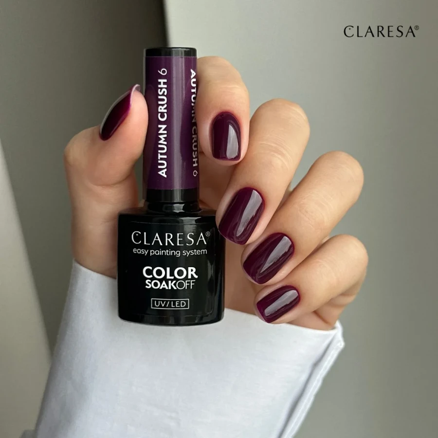 Butelka lakieru do paznokci Claresa Color Soak Off UV/LED o nazwie Autumn Crush 6 jest pokazana obok próbki fioletowego lakieru do paznokci.